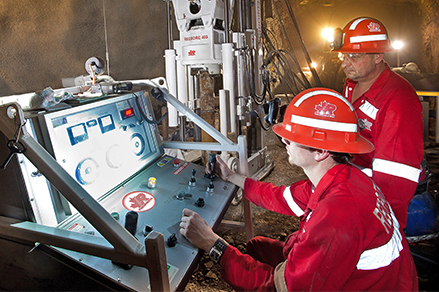 Redpath Employees operating a raisebore drill using a drill console.